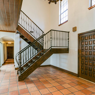 Foto di un ingresso mediterraneo di medie dimensioni con pareti beige, pavimento in terracotta, una porta a due ante, una porta marrone e pavimento arancione