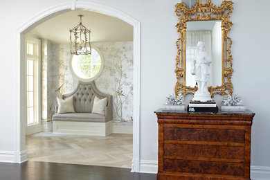 Inspiration pour une grande entrée traditionnelle avec parquet clair, un mur gris et un sol marron.