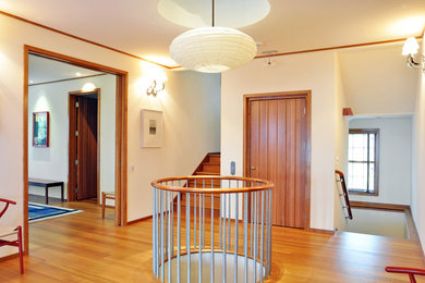 Mid-sized arts and crafts light wood floor and brown floor entry hall photo in New York with beige walls and a medium wood front door