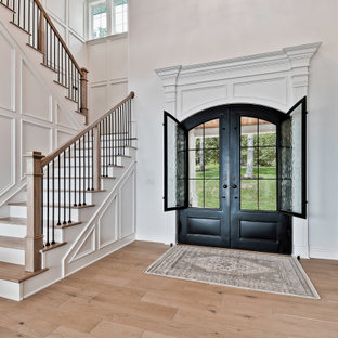 Foto de puerta principal madera, clásica, grande, con paredes blancas, suelo de madera clara, puerta doble, puerta metalizada, suelo beige y madera
