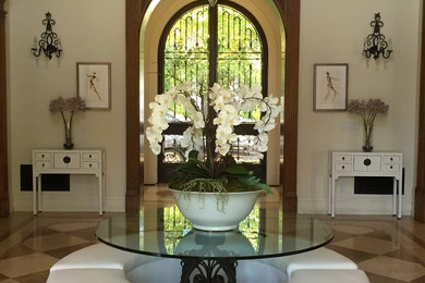 Example of a mid-sized classic marble floor and multicolored floor entryway design in Los Angeles with beige walls and a glass front door