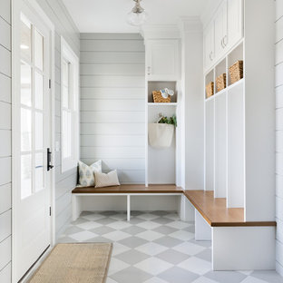 Immagine di un grande ingresso con anticamera costiero con pareti grigie, pavimento con piastrelle in ceramica, una porta singola, una porta bianca e pavimento grigio