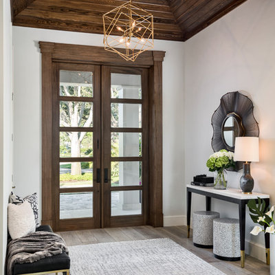 Example of a transitional gray floor and light wood floor entryway design in Other with white walls and a dark wood front door