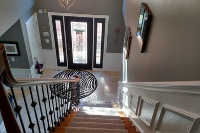 Large transitional travertine floor and beige floor entryway photo in Chicago with brown walls and a glass front door