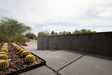Example of a large minimalist concrete floor entryway design in Phoenix with gray walls and a glass front door