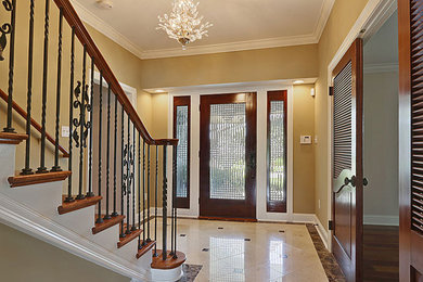 Medium sized classic foyer in New Orleans with beige walls, limestone flooring, a single front door, a glass front door and beige floors.