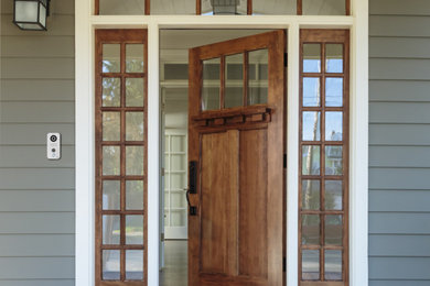 Foto de puerta principal de estilo americano de tamaño medio con paredes grises, suelo de madera clara, puerta pivotante, puerta de madera en tonos medios y suelo marrón