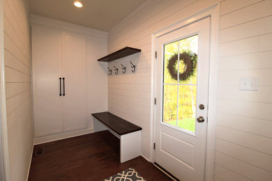 Diseño de vestíbulo posterior campestre de tamaño medio con paredes blancas, suelo de madera oscura, puerta simple, puerta blanca y suelo marrón