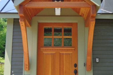 Immagine di una porta d'ingresso tradizionale di medie dimensioni con pareti verdi, una porta singola e una porta in legno bruno