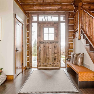 Diseño de distribuidor rural con paredes blancas, suelo de madera oscura, puerta simple y puerta de madera clara