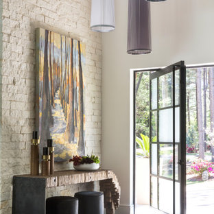 Example of a trendy dark wood floor and brown floor entryway design in Little Rock with beige walls and a glass front door