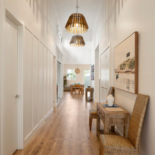 Foto de hall marinero, grande, con paredes blancas, suelo laminado, puerta doble, puerta blanca y suelo marrón