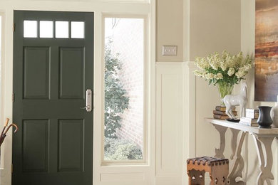 Example of a mid-sized transitional dark wood floor entryway design in Chicago with beige walls and a black front door