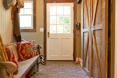 Inspiration for a cottage brick floor and red floor entryway remodel in Other with a white front door and beige walls