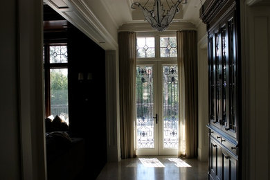 Foto de entrada contemporánea con paredes beige, suelo de mármol, puerta doble y puerta de vidrio