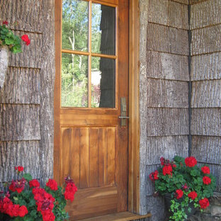 Esempio di una porta d'ingresso stile rurale con una porta singola e una porta in legno bruno