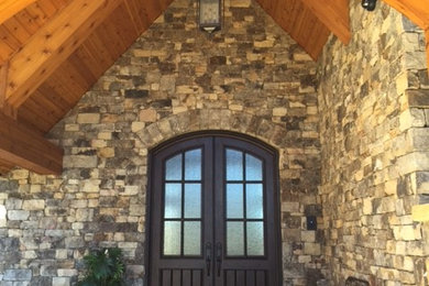 Large elegant entryway photo in Charlotte with multicolored walls and a dark wood front door