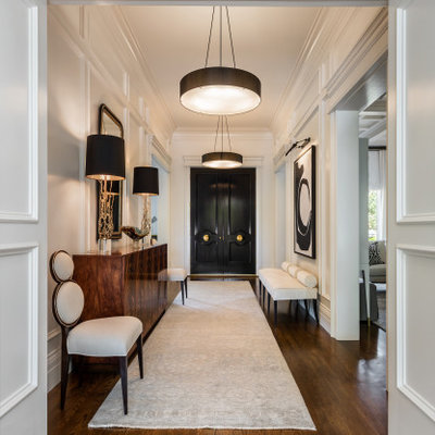Example of a mid-sized transitional medium tone wood floor and brown floor entryway design in Other with white walls and a black front door