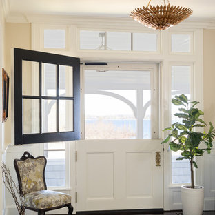 Exemple d'une porte d'entrée bord de mer avec une porte hollandaise, un mur beige, un sol en bois foncé et une porte blanche.