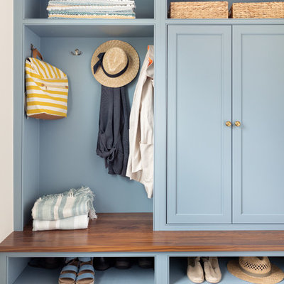 Inspiration for a coastal dark wood floor mudroom remodel in Boston with blue walls