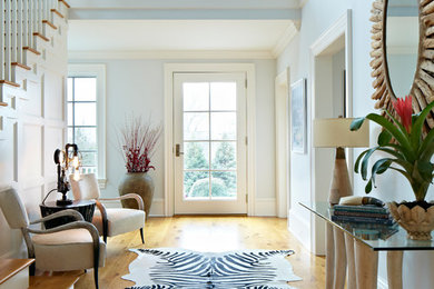 Inspiration for a mid-sized transitional medium tone wood floor entryway remodel in New York with blue walls