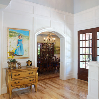 Inspiration for a timeless light wood floor foyer remodel in Charlotte with white walls