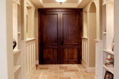 Immagine di un ingresso chic di medie dimensioni con pareti beige, pavimento con piastrelle in ceramica, una porta a due ante, una porta in legno scuro e pavimento beige