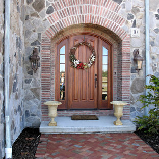 Idee per una porta d'ingresso mediterranea con una porta singola e una porta in legno bruno