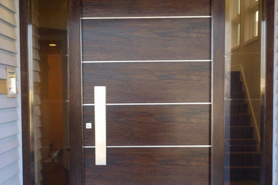 Inspiration for a contemporary entryway remodel in Los Angeles with a dark wood front door