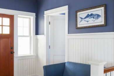 Example of a mid-sized beach style medium tone wood floor and brown floor entryway design in Boston with blue walls and a medium wood front door