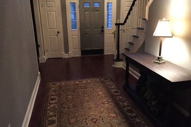 Mid-sized elegant dark wood floor entryway photo in New York with gray walls and a gray front door
