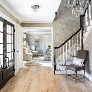 Ispirazione per un ingresso chic con pareti grigie, parquet chiaro, una porta a due ante, una porta nera e pavimento beige