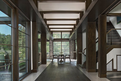 На фото: большое фойе в стиле модернизм с бежевыми стенами, полом из керамической плитки и коричневым полом