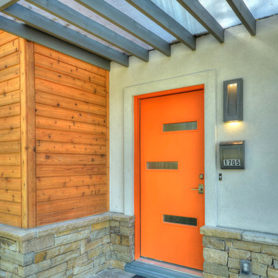 Inspiration for a mid-sized contemporary entryway remodel in Austin with an orange front door