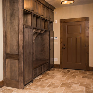 Foto di un ingresso con anticamera stile rurale di medie dimensioni con pareti beige, pavimento in travertino, una porta singola e una porta marrone