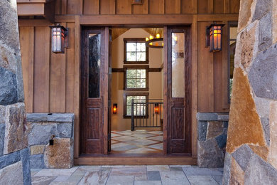 シアトルにある広いラスティックスタイルのおしゃれな玄関ドア (茶色い壁、濃色木目調のドア) の写真