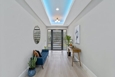 Example of a trendy light wood floor entryway design in Charleston with white walls and a black front door
