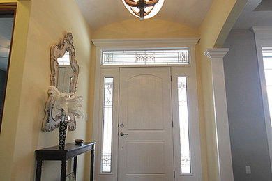 Foto de entrada clásica renovada con paredes amarillas, puerta simple y puerta blanca