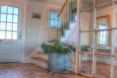 Ejemplo de distribuidor clásico de tamaño medio con paredes beige, suelo de madera oscura, puerta simple, puerta blanca y suelo marrón
