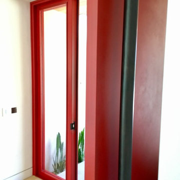 Red Steel Pivot Door on a Modern Masterpiece in La Costa