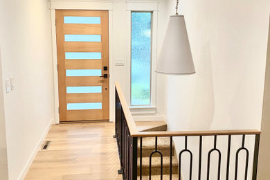 Small light wood floor and beige floor entryway photo in Portland with white walls and a light wood front door
