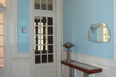 Esempio di un ingresso o corridoio american style con pareti blu, parquet chiaro, una porta bianca e pavimento marrone