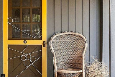 Foto på en mellanstor funkis ingång och ytterdörr, med grå väggar, betonggolv, en enkeldörr och en gul dörr