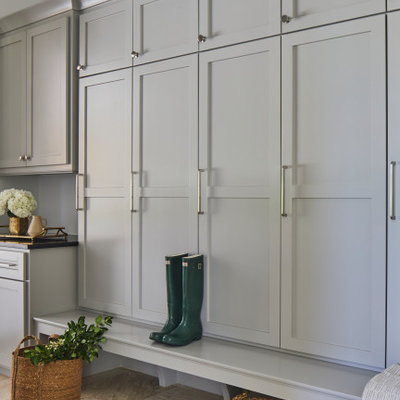 Example of a large transitional travertine floor and beige floor mudroom design in Other with white walls