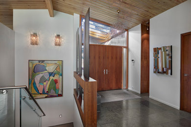 Diseño de entrada vintage con paredes blancas, puerta doble y puerta de madera en tonos medios