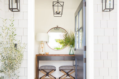 Entryway - coastal light wood floor entryway idea in Orange County with white walls and a blue front door