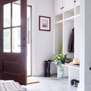 Diseño de vestíbulo posterior de estilo de casa de campo, de tamaño medio, con paredes blancas, puerta simple, puerta de madera oscura, suelo gris y suelo de baldosas de porcelana