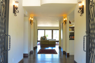 Photo of a large mediterranean foyer in Other with white walls, dark hardwood flooring, a double front door, a metal front door and brown floors.