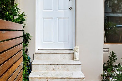 シドニーにあるお手頃価格の小さなトラディショナルスタイルのおしゃれな玄関ドア (ベージュの壁、トラバーチンの床、白いドア) の写真