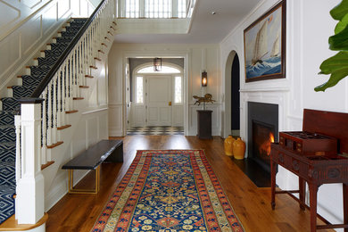 Entryway - mid-sized traditional medium tone wood floor and brown floor entryway idea in New York with white walls and a white front door